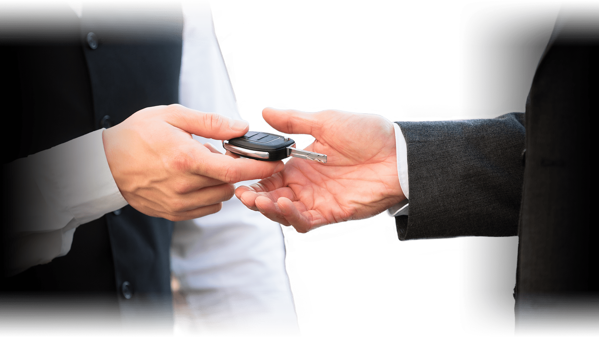 closeup of a customer handing his car key to a vallet attendent